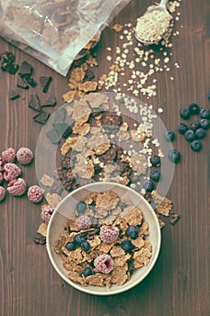Flakes with berries in brown bowl