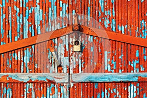Flaking paint on old wooden planks of locked door
