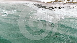 Flakstad Skagsanden surfers beach Norway winter aerial 4k video over Lofoten Archipelago , fjord covered in snow, polar circle