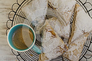 Flaky pastries on rack with cup of coffee