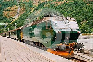 Flam, Norway. Famous Railroad Flamsbahn. Green Norwegian Train Near Railway Station photo