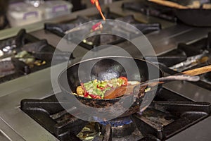 Flambe Chef Cooking in Kitchen. Professional chef in a commercial kitchen cooking flambe style. Chef Flambe Cooking