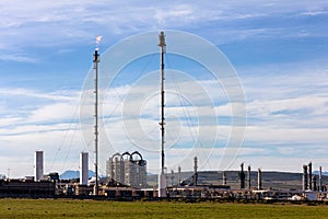 Fuel refinery with chimney and furnace.  Blue sky overhead
