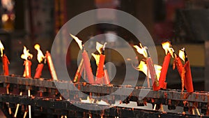 Flame from burning red chinese candle in the temple