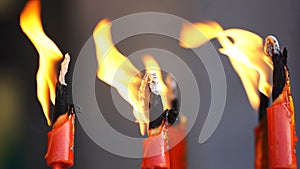 Flame from burning red chinese candle in the temple