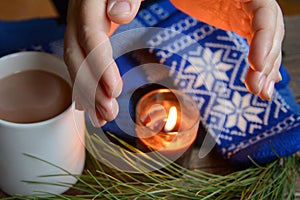 Flame from a candle warms hands photo