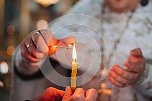 the flame of church candles at the ceremony of baptism of a child in the church