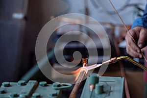 Flame of a copper welding machine heats a copper pipe in a workshop