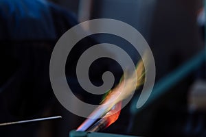 Flame of a copper welding machine heats a copper pipe in a workshop