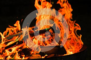 Flame. Fire.Firewood burning in bonfire. Flames on a black background.Fireplace with logs and flames. Tongues of flame