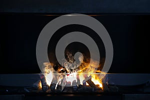 Flame of firewood burning in modern fireplace