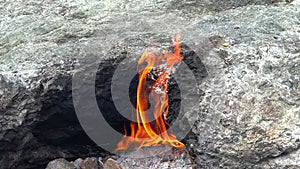 Flame of Methane Underground Emerges From Crack Between Rocks and Burns to Earth