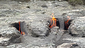 Flame of Methane Underground Emerges From Crack Between Rocks and Burns to Earth