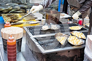 Flame of scallops ~ A kind of street snack Korean food style at Myeong-dong street food, Seoul, South Korea photo