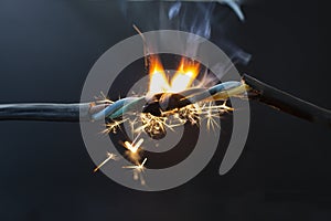 flame smoke and sparks on an electrical cable, fire hazard concept