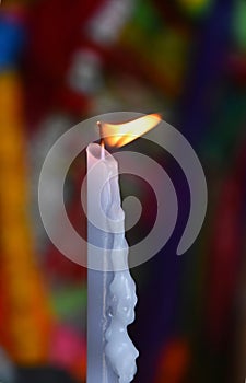 Flame of white melting candle in temple or church