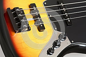 Flamed bass guitar detail with pickups and strings