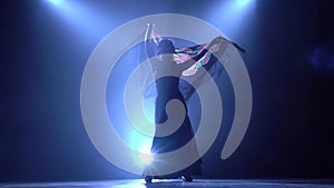 Flamenco. Girl is dancing with a manton in the hands of a Spanish incendiary dance. Llight from behind. Smoke background