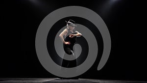 Flamenco. Girl is dancing a Spanish incendiary dance. Black background. Llight from behind