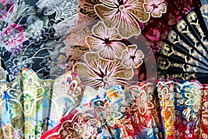 Flamenco hand fans with colorful floral pattern bunched together for abstract background. Spanish or Chinese influence