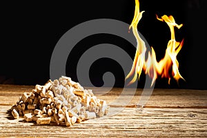Flames burning behind a heap of wood pellets