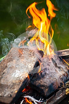 Flames from the fire on the wooden boards. Small flames close up