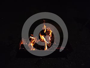 Flames for making charcoal on a fish grill, using wood burned over a large fire.