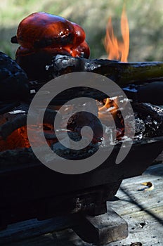 Flames smoke peppers on hibachi grill outdoors