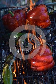 Flames smoke peppers on hibachi grill outdoors