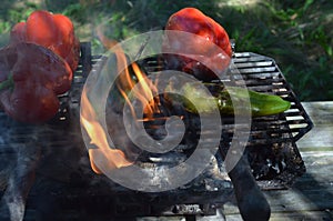 Flames smoke peppers on hibachi grill outdoors