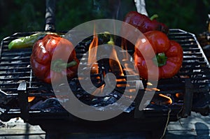 Flames smoke peppers on hibachi grill outdoors