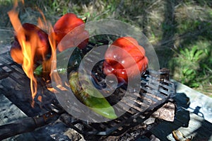 Flames smoke peppers on hibachi grill outdoors