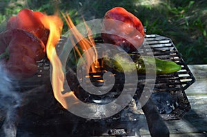 Flames smoke peppers on hibachi grill outdoors