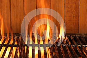 Flaming BBQ Charcoal Cast Iron Grill And Wood Background