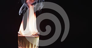 A flaming cocktail ignites with dramatic effect, with copy space