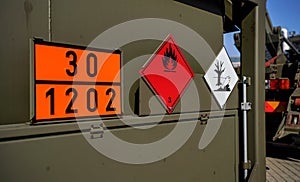 Flammable and dangerous -  Hazardous marine pollutant substance - sign on brown green metal side of army petrol or fuelling