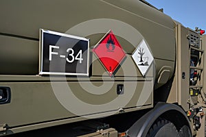 Flammable and dangerous -  Hazardous marine pollutant substance - sign on brown green metal side of army petrol or fuelling