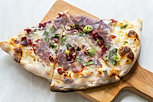 Flammkuchen Pizza Slices / Traditional Tarte Flambee with Creme Fraiche, Cream Cheese, Bacon and Red Onions on Wooden Board