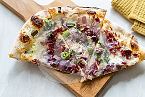 Flammkuchen Pizza Slices / Traditional Tarte Flambee with Creme Fraiche, Cream Cheese, Bacon and Red Onions on Wooden Board
