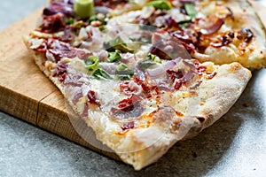 Flammkuchen Pizza Slices / Traditional Tarte Flambee with Creme Fraiche, Cream Cheese, Bacon and Red Onions on Wooden Board