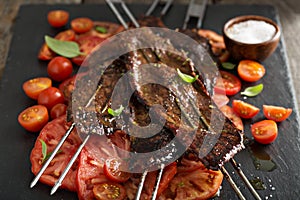 Flank steak on skewers with tomatoes