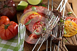 Flank steak on skewers with tomatoes