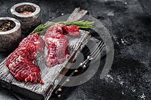 Flap steak flank raw cut and Machete skirt steak on wooden board. Black background. Top view. Copy space