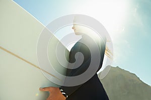 Flare, sky at beach and woman with surfboard in summer from below for travel, vacation or holiday. Exercise, fitness or