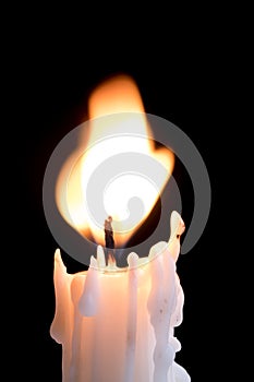 Flaring flame on top of a white candle