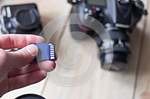 flash card in hand on camera background, memory card for SLR camera, flash drive, photo