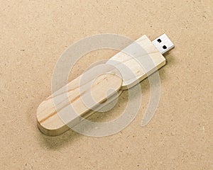 Flash drive on brown cardboard texture background.  USB stick made from wood material concept