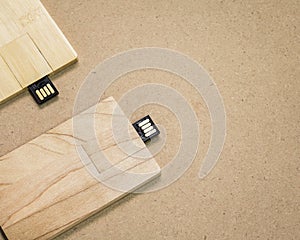 Flash drive card on brown cardboard texture background.  USB stick made from wood material concept