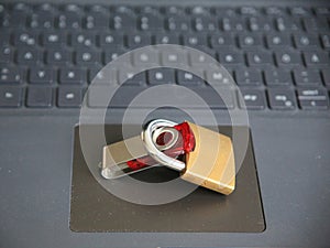 Flash drive and padlock on the laptop; information security concept