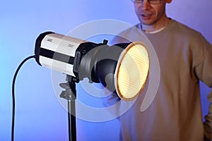 A flash with a modifier on with a diffuser with a person